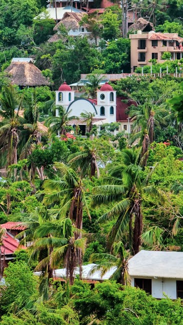 Vista panoramica dell'ecogarden di Mathi, un'oasi verde con palme, vegetazione lussureggiante e architetture integrate nel paesaggio naturale.