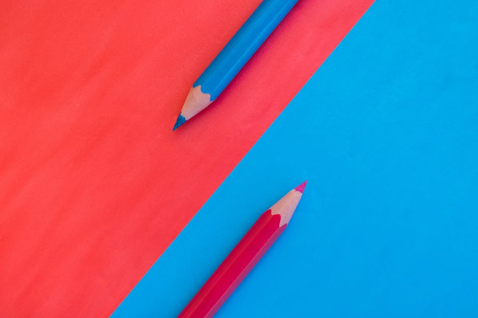Due matite colorate su sfondo diviso rosso e blu, metafora del passaggio dalla primaria alle medie, consigli pratici per studenti.