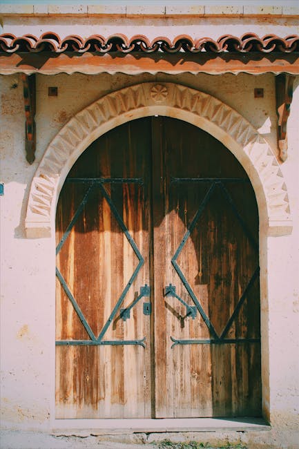 Porta antica in legno con decorazioni geometriche a forma di parallelogramma, simbolo di unicità e simmetria architettonica.
