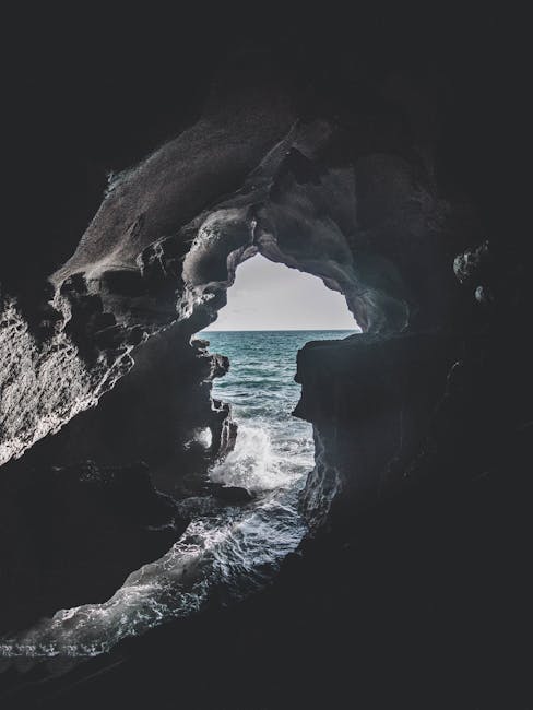 Grotta marina con vista sull'oceano, simbolo di rifugio e contemplazione nella natura, ispirazione per le Bucoliche e la poesia pastorale.