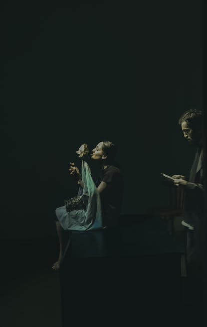 Donna con maschera teatrale e uomo con tablet, metafora delle dinamiche di ruolo e supplenze nel contesto scolastico 2026/27