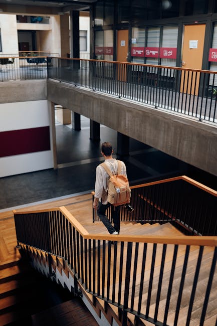 Studente con zaino scende le scale in un edificio universitario, simbolo del percorso per diventare professore di inglese.