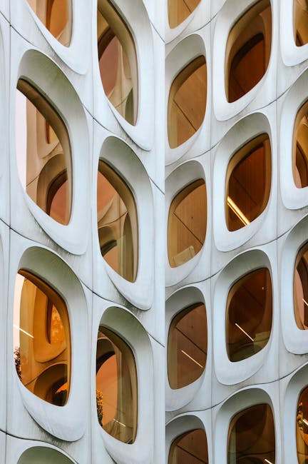 Facciata di edificio con finestre ovali adiacenti, riflessi geometrici e design moderno per articolo su angoli adiacenti.