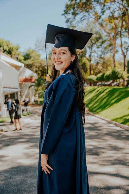 Studentessa universitaria sorridente con toga e tocco, simbolo di successo accademico e traguardo raggiunto dopo le lezioni universitarie.