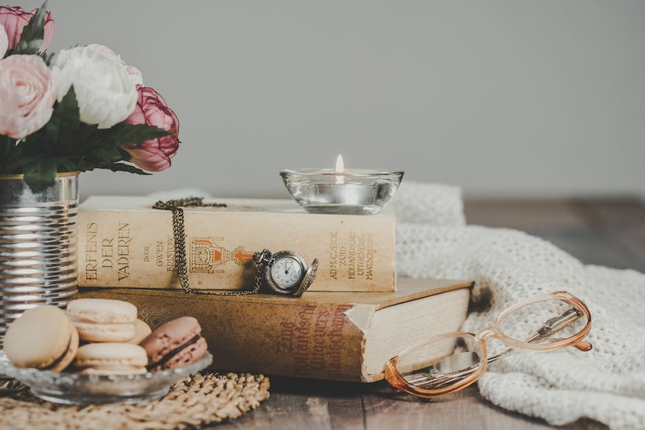 Natura morta con libri antichi, macarons, candela e orologio da tasca. Concetto di tempo di lettura ideale e relax letterario.