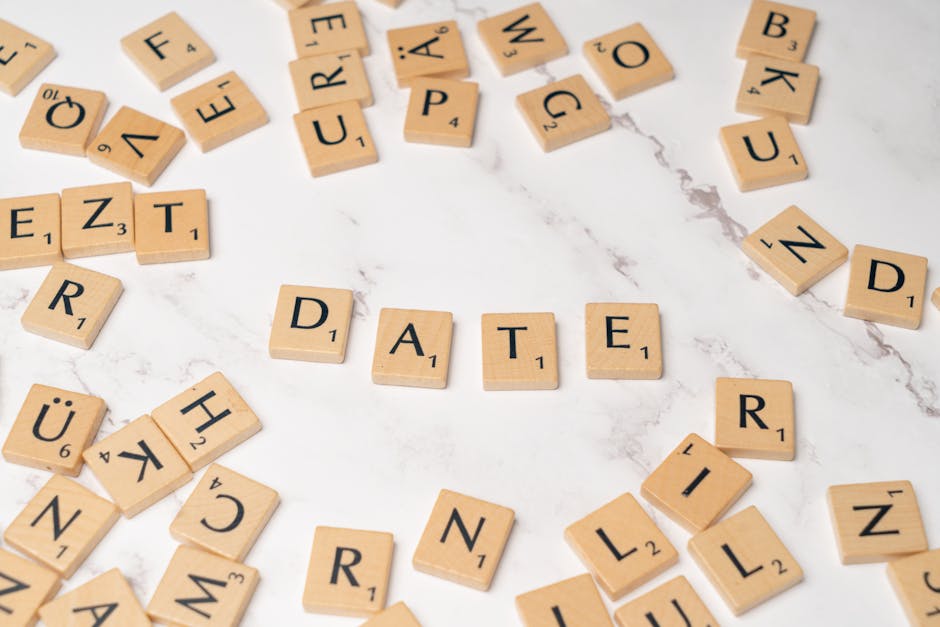 Scadenza bonus mamme 2025: la parola DATE scritta con tessere di Scrabble evidenzia l'ultimo giorno utile per la domanda.