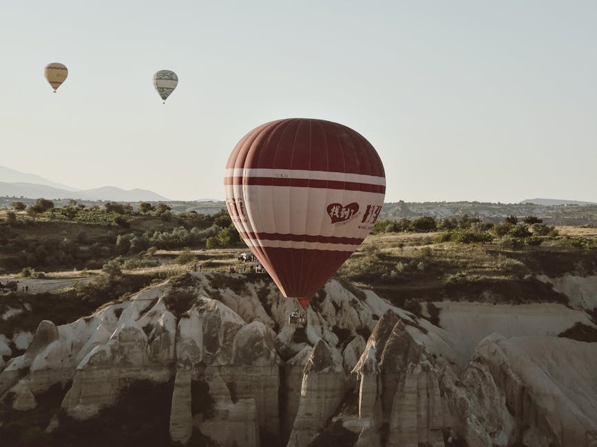 Mongolfiere colorate che sorvolano le formazioni rocciose uniche della Cappadocia, un'esperienza indimenticabile da Eneo.