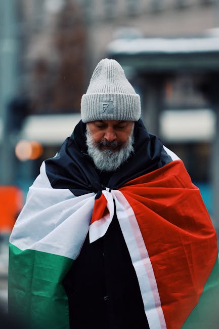 Uomo con bandiera palestinese: simbolo di dissenso e riflessioni sull'inciviltà politica italiana e la tolleranza verso le minoranze.