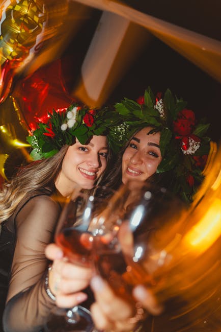 Festeggiamenti diploma ITS Academy: due studentesse laureate brindano con corone d'alloro e calici di vino rosso, simbolo di successo e futuro.