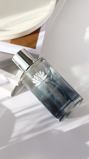 Flacone di profumo Healy Mood su sfondo bianco con ombre, fragranza per il benessere e la cura personale