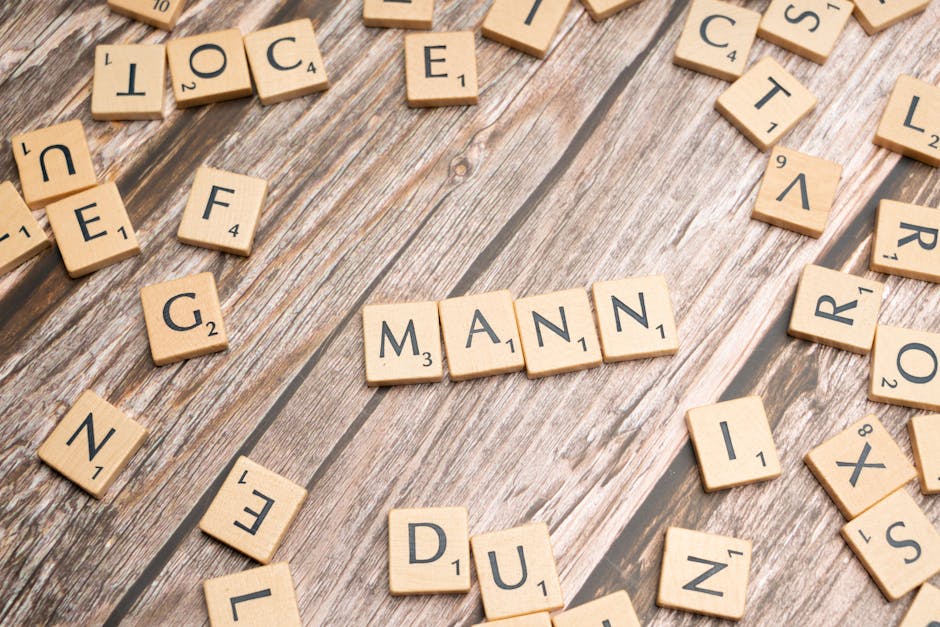Parola MANN scritta con tessere di Scrabble su sfondo di legno, metafora del ruolo della famiglia nel benessere individuale