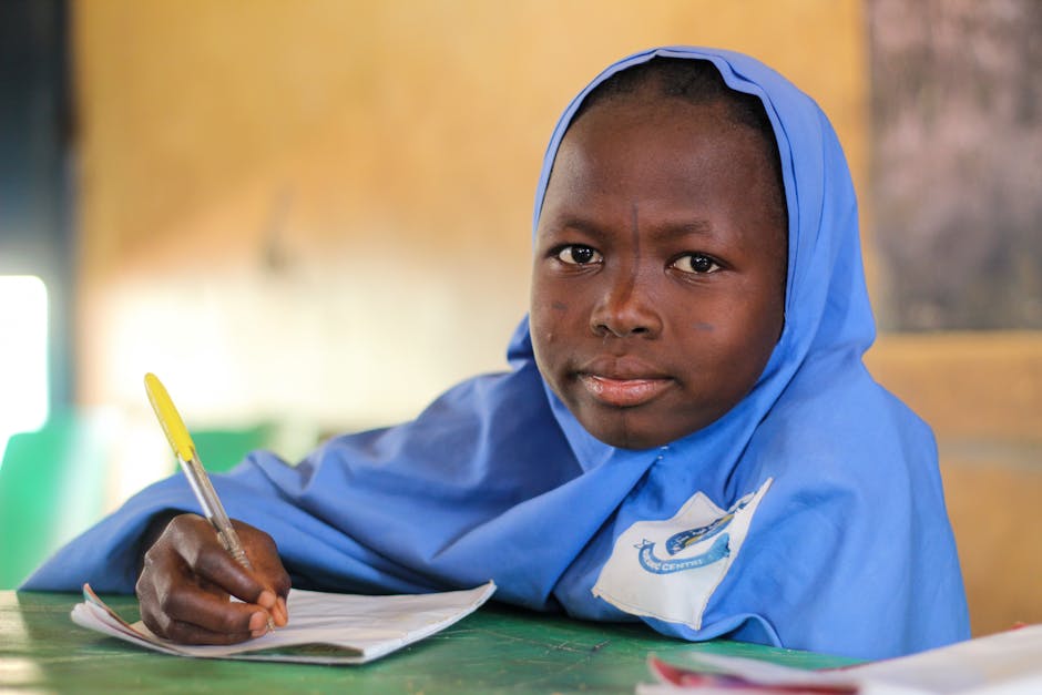 Ragazza africana studia a scuola: focus sull'importanza dell'istruzione femminile per la parità di genere e retributiva futura.
