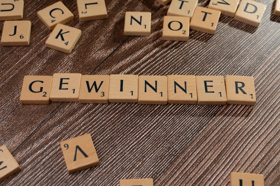 Parole 'Gewinner' (vincitore in tedesco) con tessere di Scrabble su sfondo legno, metafora successo rimborso unico