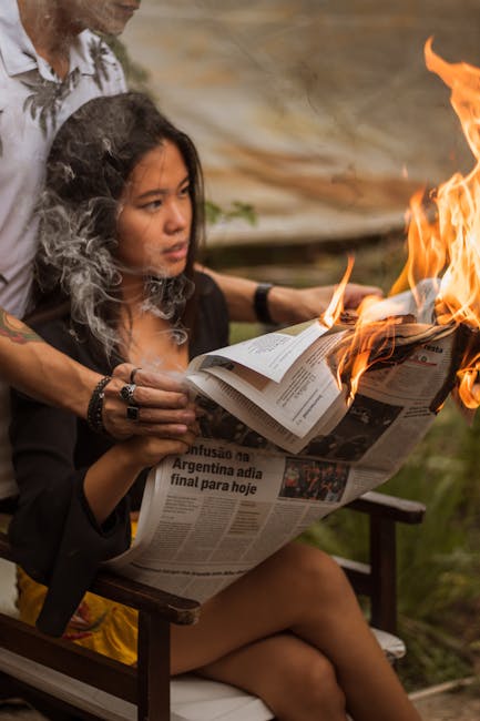 Donna che brucia un giornale, simbolo di intersezione e unicità come le rette incidenti nella geometria euclidea.