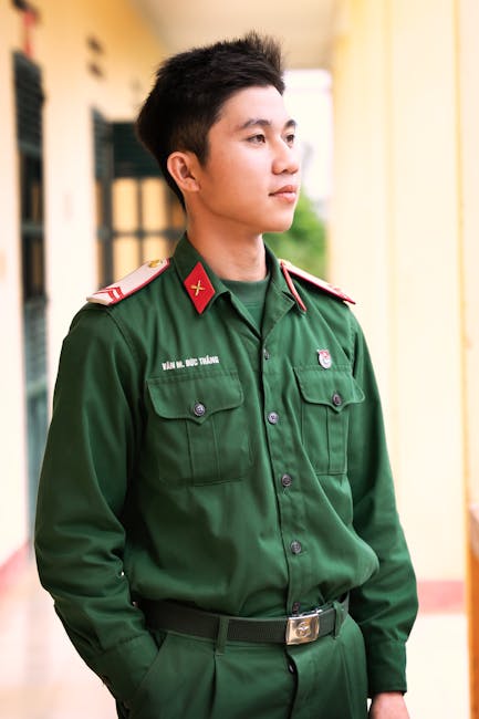 Giovane militare in uniforme verde, simbolo dell'addestramento distintivo delle forze armate moderne e preparazione al servizio.