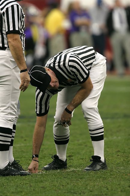 Arbitro di football americano segna il campo, simbolo di rispetto delle regole e autorità, esempio per i giovani come Samuele.