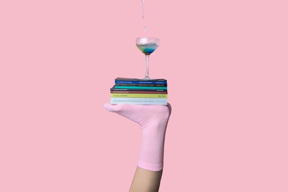 Tecniche di apprendimento: mano con calzino rosa che regge libri e un bicchiere pieno d'acqua, metafora dello studio efficace.