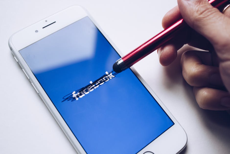 Smartphone con logo Facebook cancellato, simbolo della dipendenza giovanile dai social media e delle responsabilità di Zuckerberg.