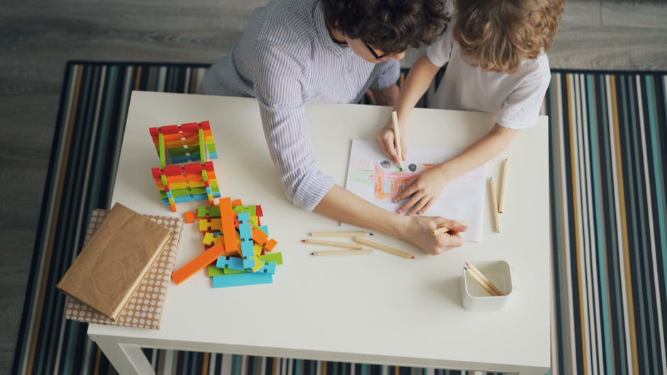 Madre e figlio disegnano insieme: ambiente di apprendimento supportivo con colori, matite e costruzioni per stimolare la creatività infantile.