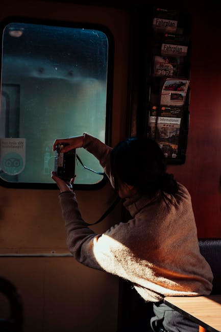 Donna fotografa attraverso il finestrino di un treno, metafora della pianificazione scolastica autunnale e analisi documentale.