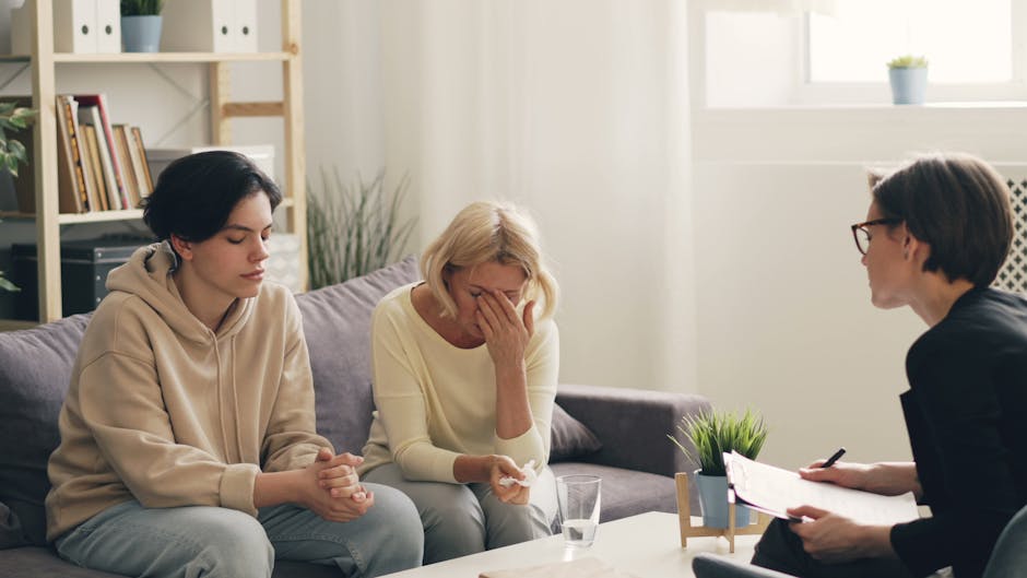 Consulenza medica e salute renale: donna in lacrime e giovane durante colloquio con specialista per valutazione del Calcolo Filtrato Glomerulare.