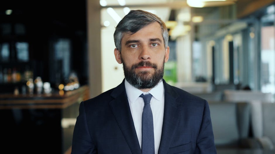 Uomo in giacca e cravatta con espressione seria, simbolo di preparazione e concentrazione per affrontare un esame unico con successo.