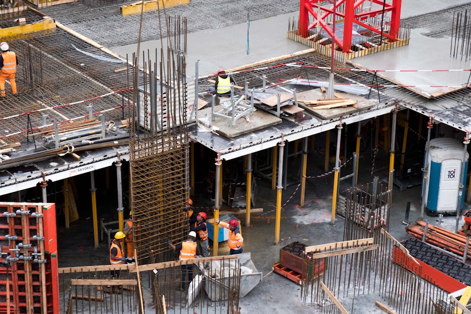 Cantiere scolastico in costruzione: operai al lavoro, armature in acciaio, sicurezza e responsabilità per i Dirigenti scolastici.