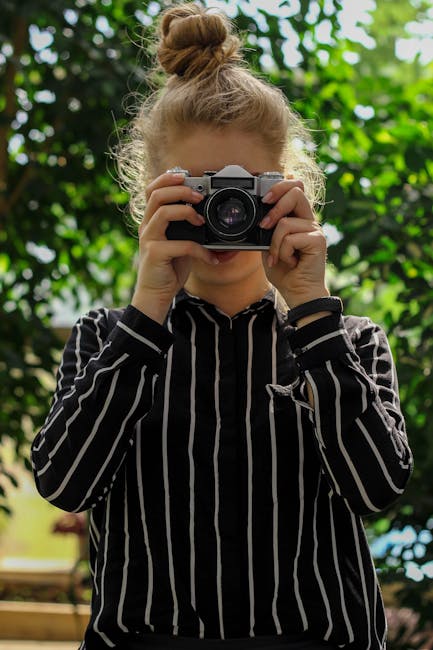 Ragazza fotografa con macchina fotografica vintage, ispirazione Fibonacci nella composizione visiva e armonia estetica della scena.