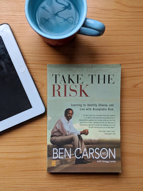 Tablet digitale affiancato a libro cartaceo Take the Risk di Ben Carson e tazza, metafora transizione lettura digitale