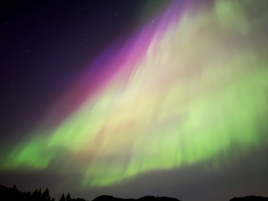 Aurora Boreale: Magia nel Cielo Artico Spettacolare aurora boreale con sfumature verdi e viola nel cielo notturno artico, esperienza indimenticabile sotto le stelle.