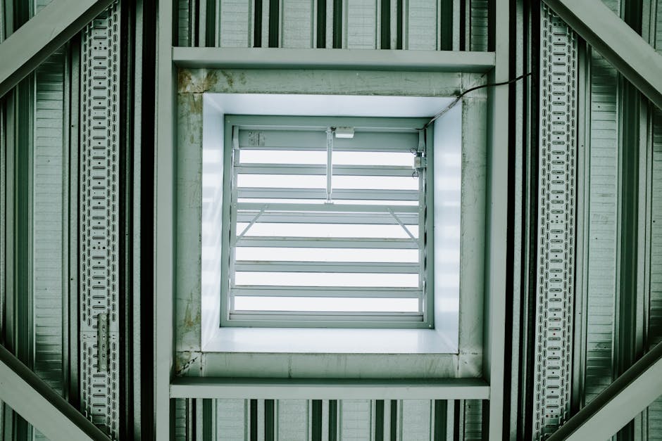 Dettaglio angoloidi: vista dal basso di una griglia di ventilazione integrata in una struttura metallica complessa con elementi angolari.