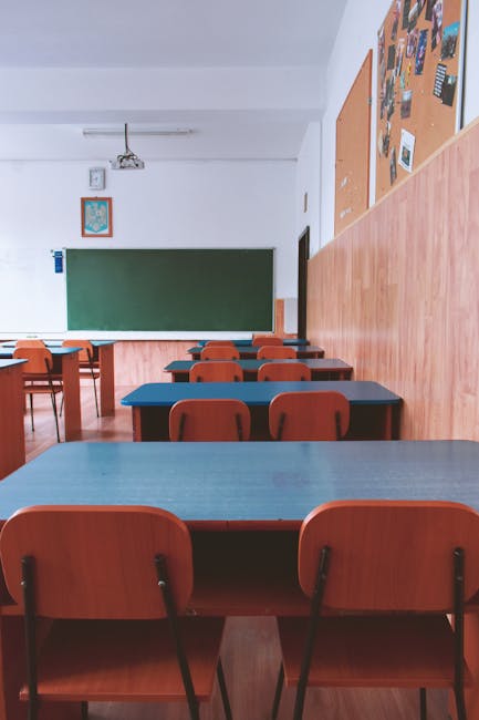 Aula scolastica vuota con banchi e sedie, focus sull'importanza della collaborazione degli studenti per mantenere l'ordine e il decoro.