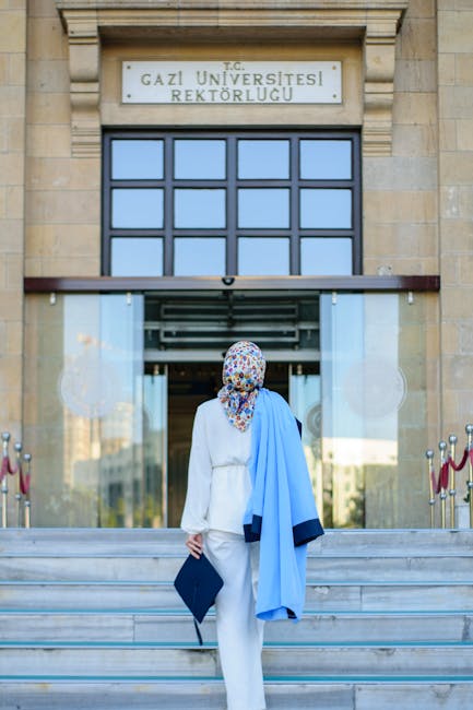 Studentessa con toga e tocco si avvia verso l'ingresso dell'università Gazi, simbolo di un futuro nell'istruzione superiore europea.