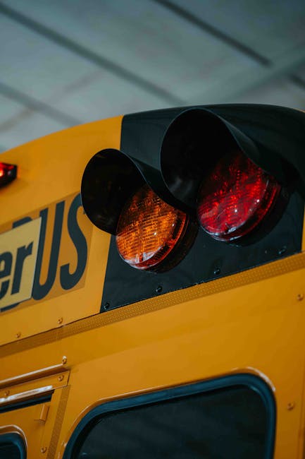 Fanali posteriori di scuolabus giallo: dettaglio luci di stop per sicurezza nei viaggi di istruzione e trasporto scolastico.