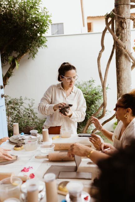 Gruppo di persone partecipa a un workshop di ceramica all'aperto, promuovendo la partecipazione attiva e la creatività condivisa.