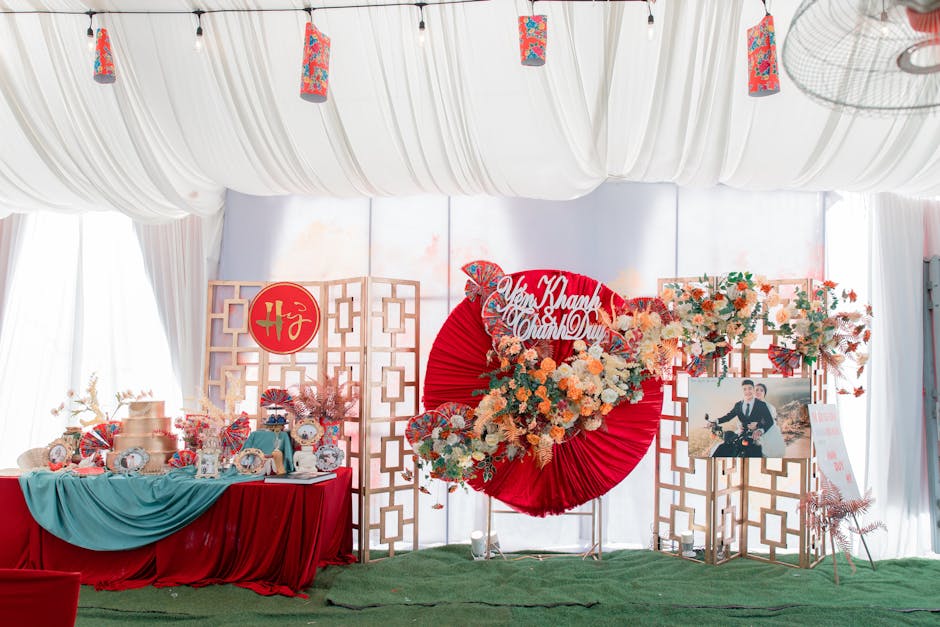 Allestimento scenografico per evento a tema con decorazioni floreali e dettagli rossi e oro