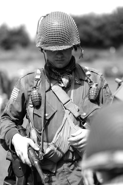 Soldato americano della Seconda Guerra Mondiale con elmetto e granate, simbolo di un conflitto senza precedenti e di unicità storiche.