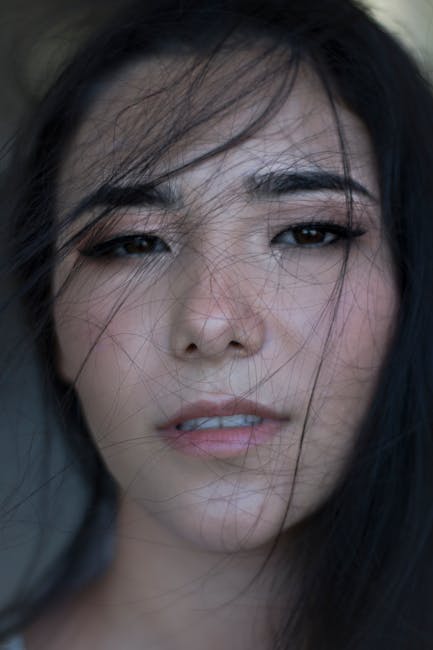 Ritratto di donna con capelli scuri che intersecano il viso, metafora visiva delle rette incidenti e delle loro connessioni complesse.