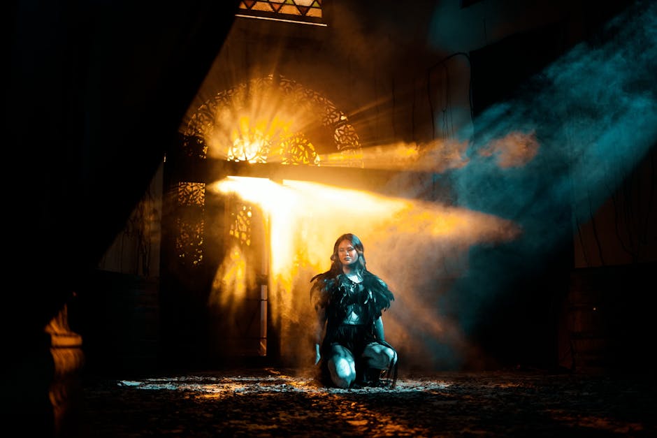 Donna in ginocchio illuminata da fasci di luce dorata e azzurra, concetto di forza e determinazione per calcolo massa muscolare