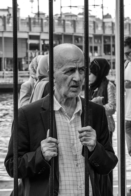 Uomo anziano dietro le sbarre: una storia di resilienza e speranza, immagine evocativa per tecniche di storytelling efficaci.