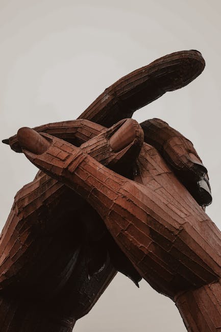 Scultura lignea di mani che scrivono, simbolo dell'eredità culturale prussiana e del suo contributo alla storia europea.