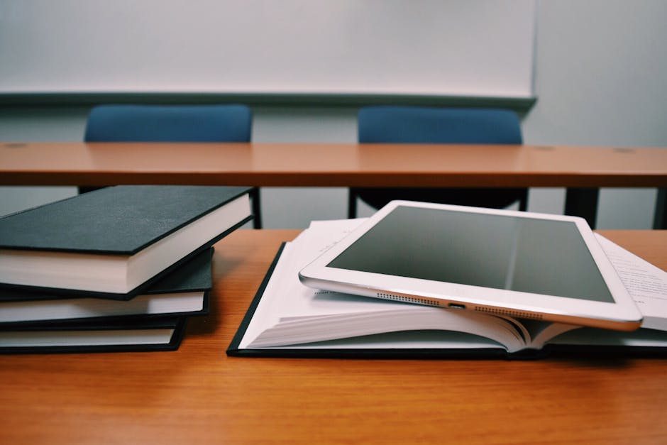 Libri e tablet su un banco di scuola, contrasto tra digitale e cartaceo in classe dopo la decisione svedese di abbandonare i tablet.