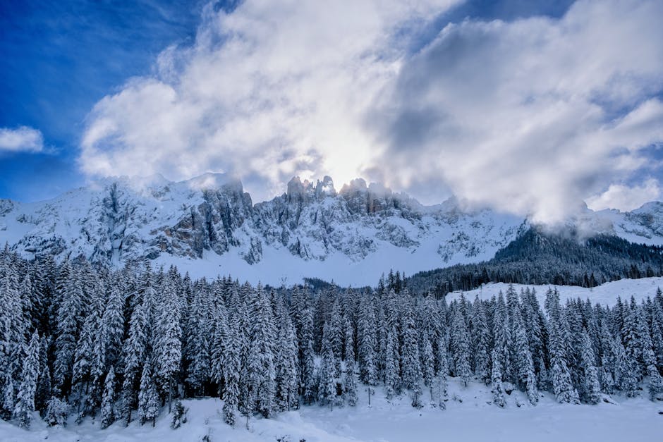 Paesaggio invernale montano innevato con cielo nuvoloso, ideale per illustrare il periodo delle vacanze di Natale e il rientro a scuola.