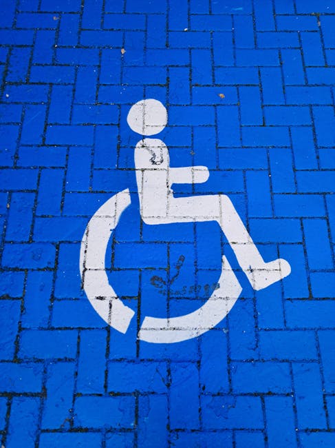 Simbolo di accessibilità per disabili su pavimentazione blu, in riferimento ai posti disponibili per il sostegno scolastico e universitario.