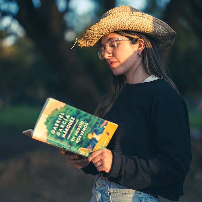 Donna legge Gabriel Garcia Marquez, 'En Agosto Nos Vemos', cappello di paglia. Omaggio al realismo magico dello scrittore colombiano.