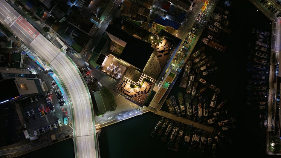 Vista aerea notturna di un porto con barche ormeggiate e illuminazione urbana, metafora dei divari nel sistema scolastico italiano.