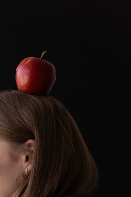 Mela rossa in equilibrio sulla testa di una donna, metafora di equilibrio e classificazione sanitaria ICD 11