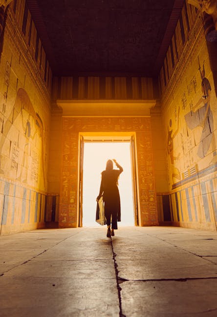 Donna che esplora un tempio antico con geroglifici, evocando i misteri e le leggende di civiltà perdute come Troia.