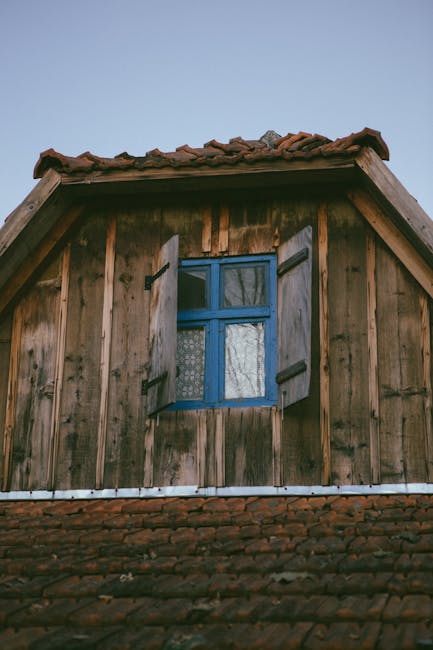 Finestra azzurra con persiane in legno su edificio rustico: un approccio distintivo per valutare l'architettura sostenibile.