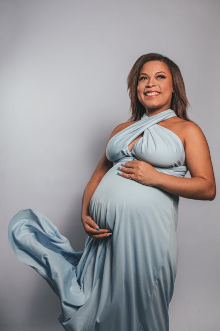 Giovane donna incinta sorridente con abito azzurro, simbolo di speranza e futuro per il benessere psicologico delle nuove generazioni.